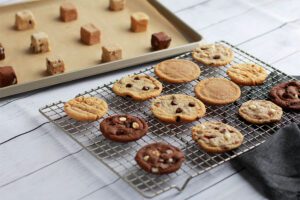 Wooden Spoon Cookies on cooling rack next to tray of cookie dough cubes